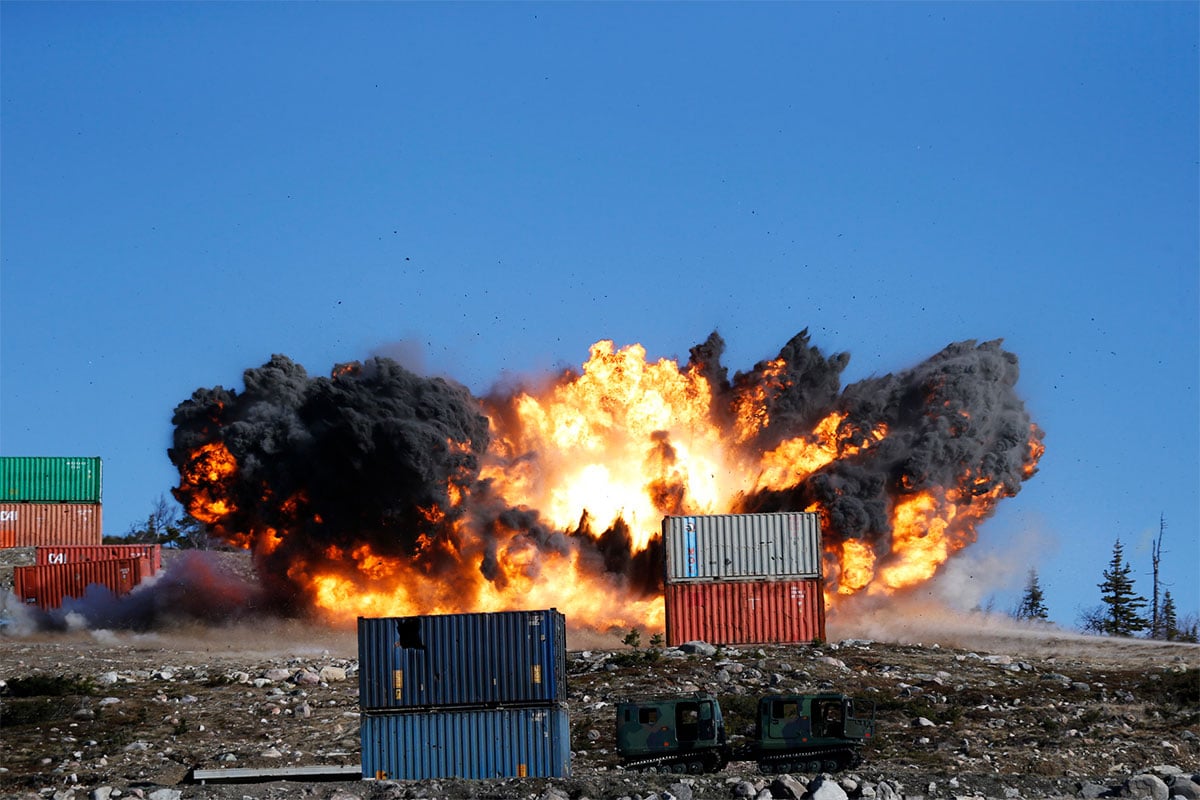Large explosion behind static container targets, after impact of precision guided bomb
